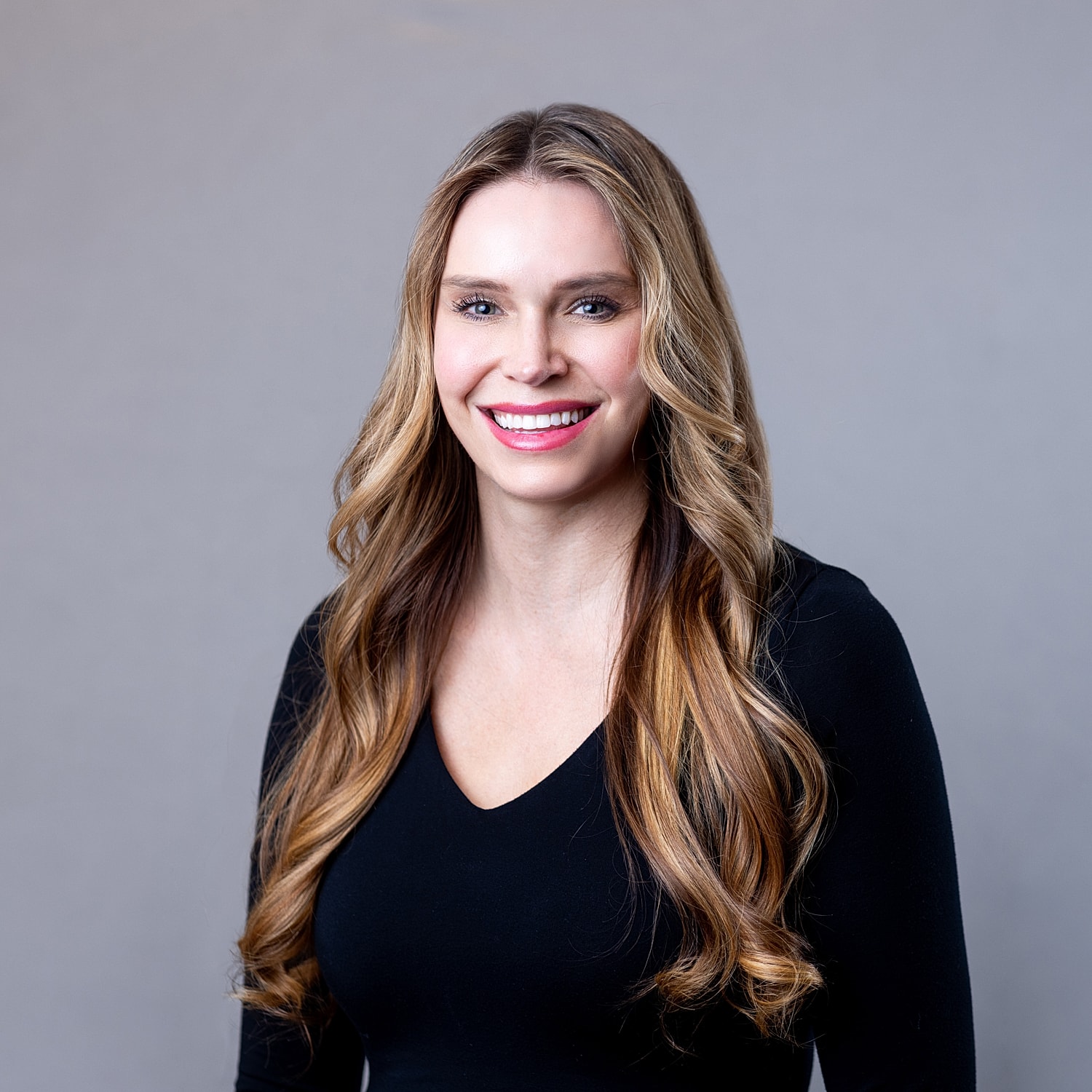 Smiling woman with long, wavy hair.
