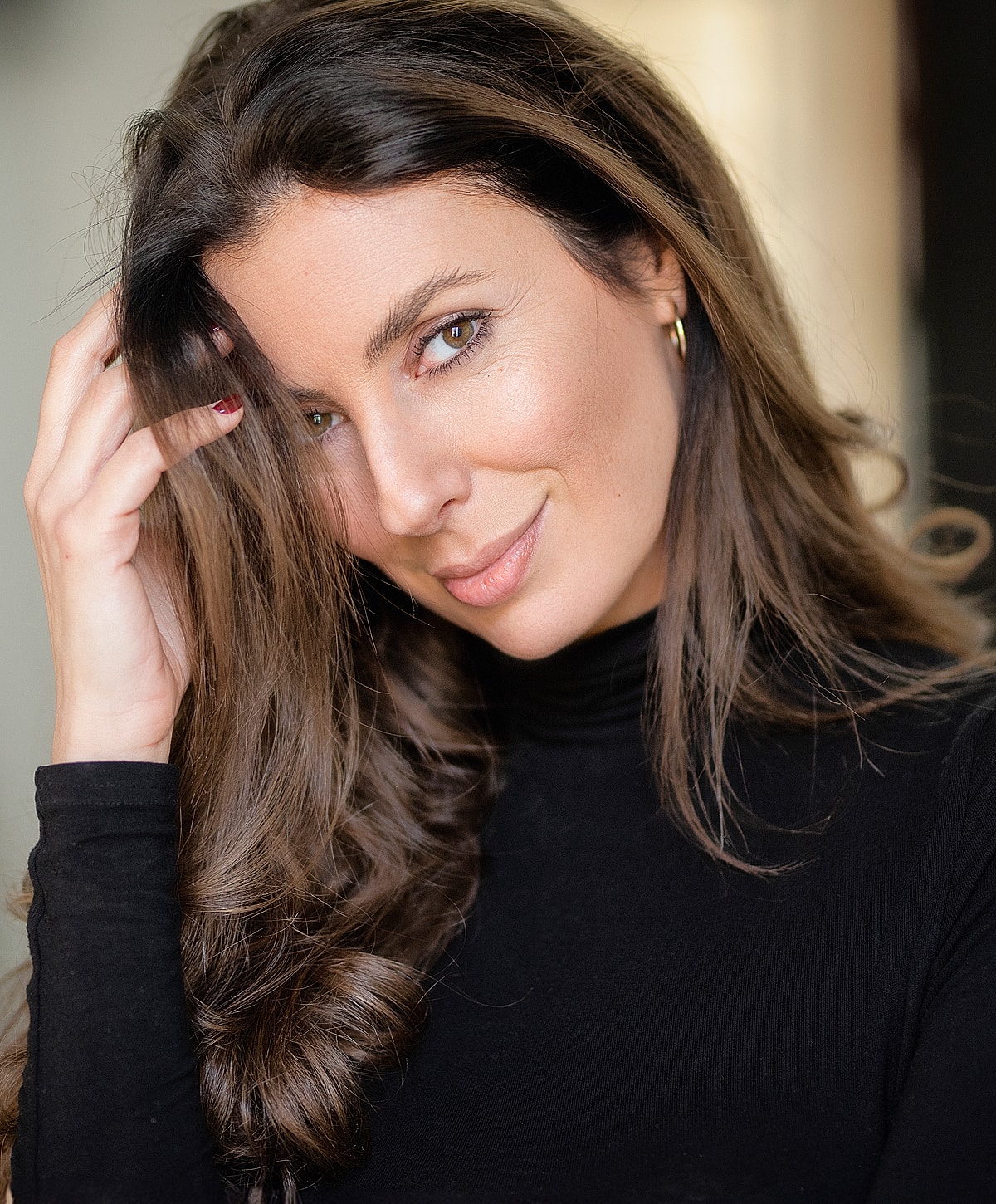 Woman with long hair smiling in black shirt.