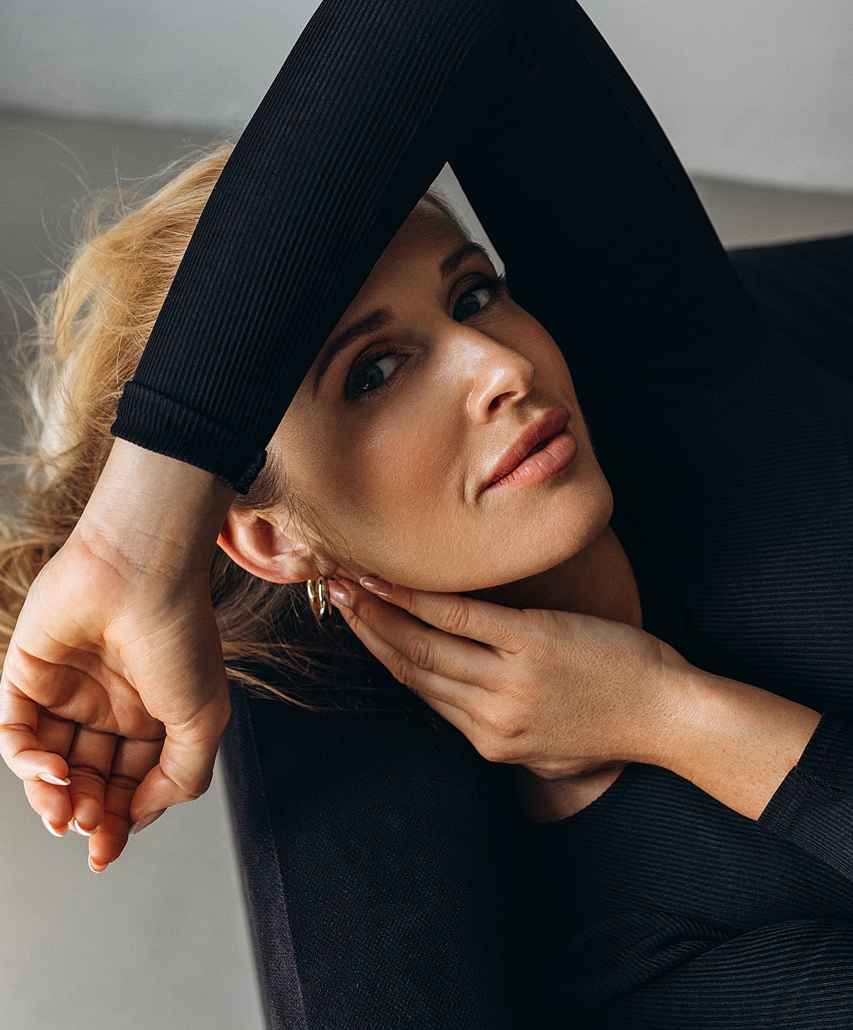 Woman relaxing with arm over head, stylish pose.