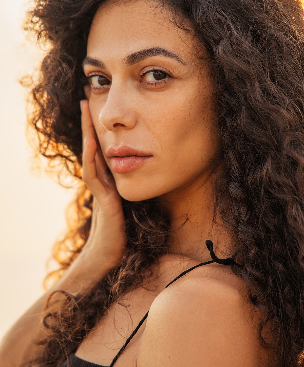 Woman with curly hair and natural makeup.