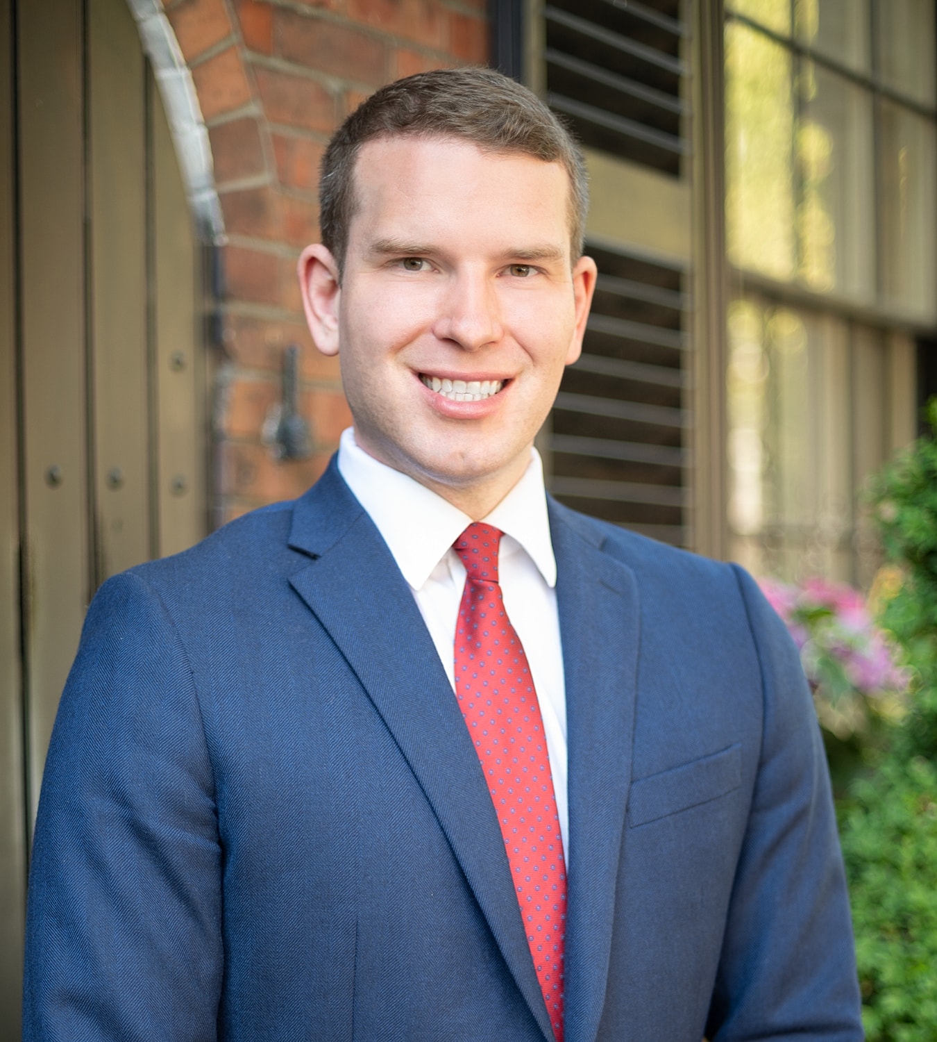 Man in suit smiling outdoors.