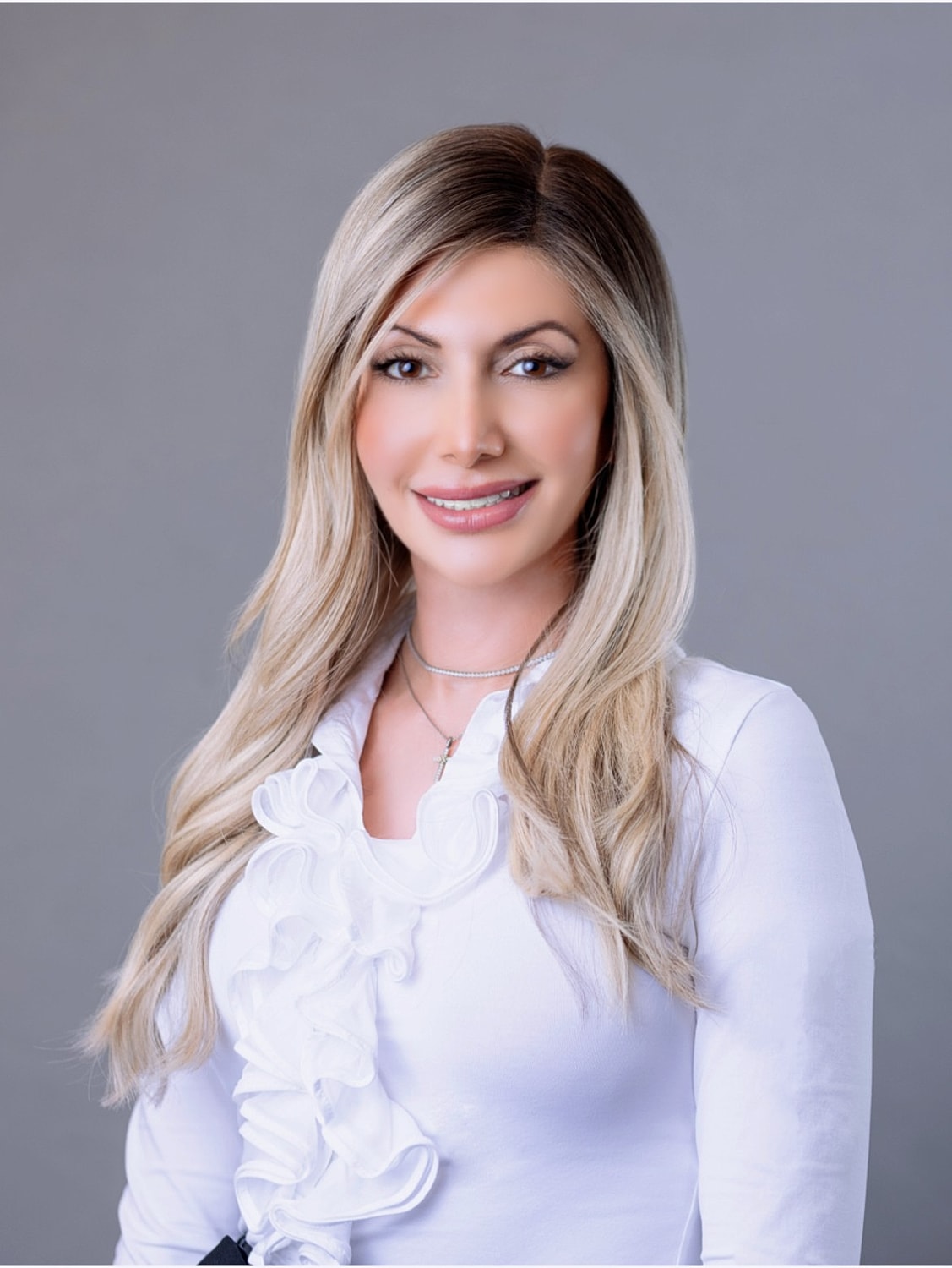 Professional woman with long hair and white blouse.