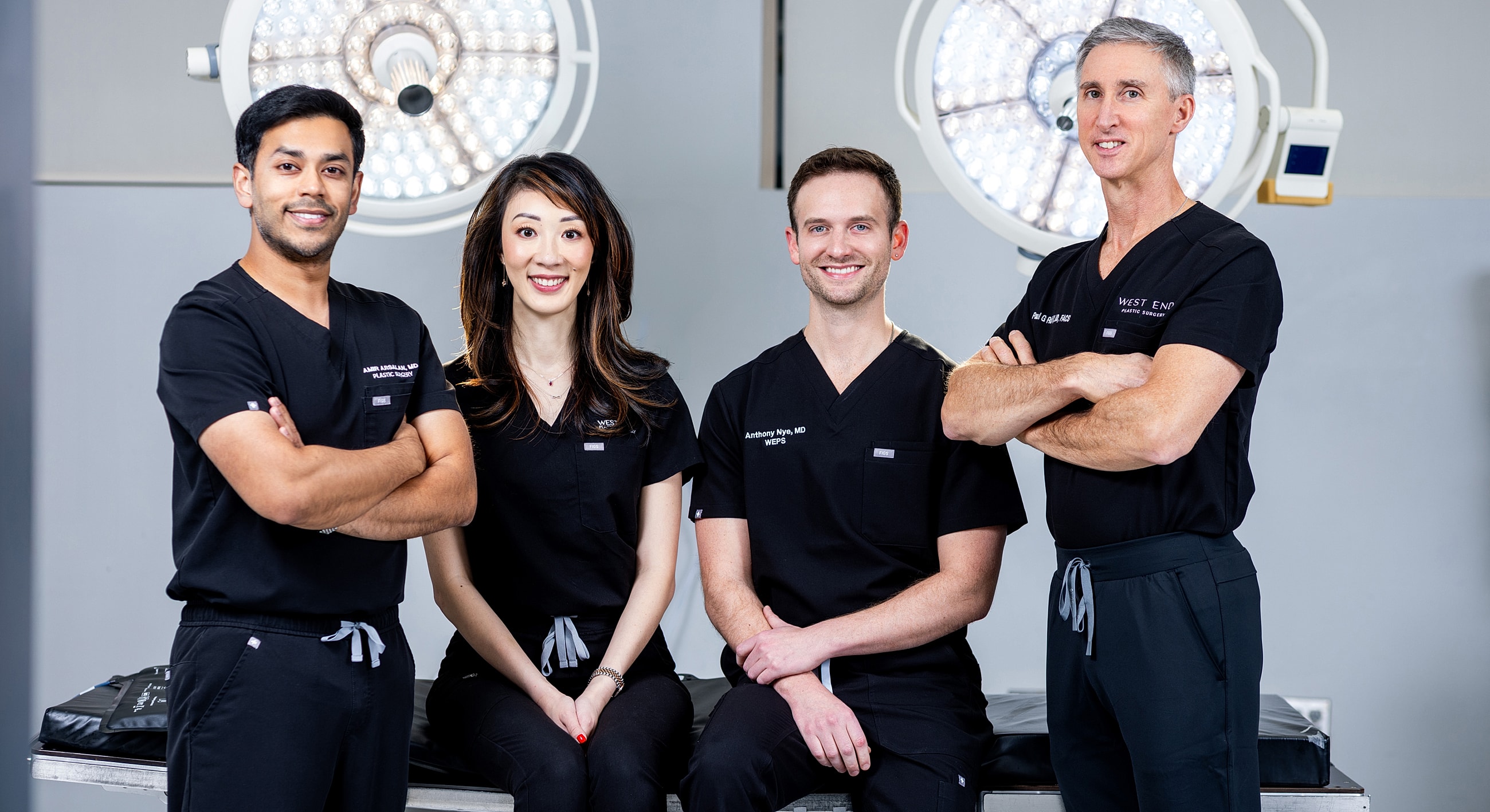 Medical team posing in surgical attire.