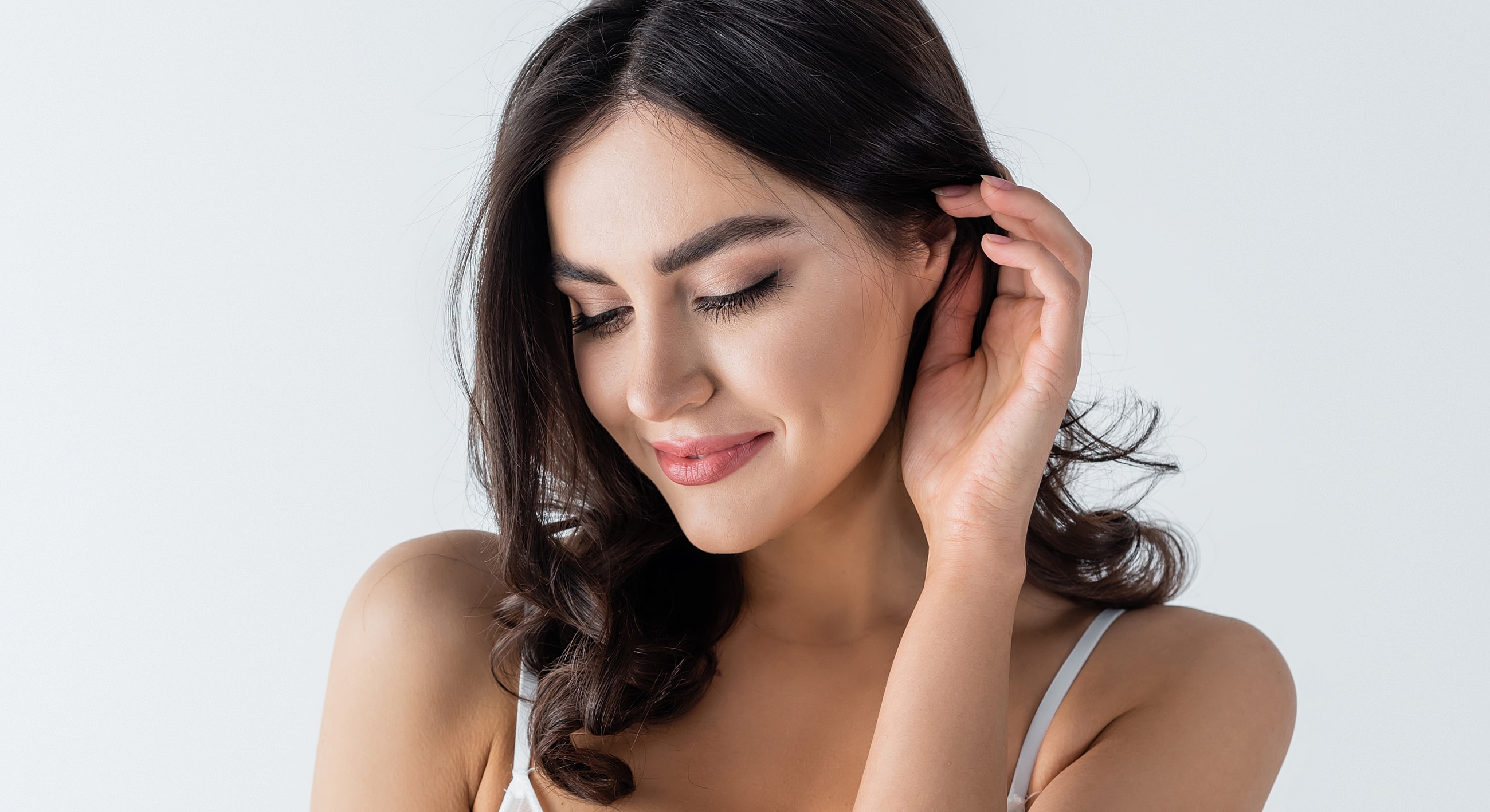 Woman with gentle smile and soft gaze.