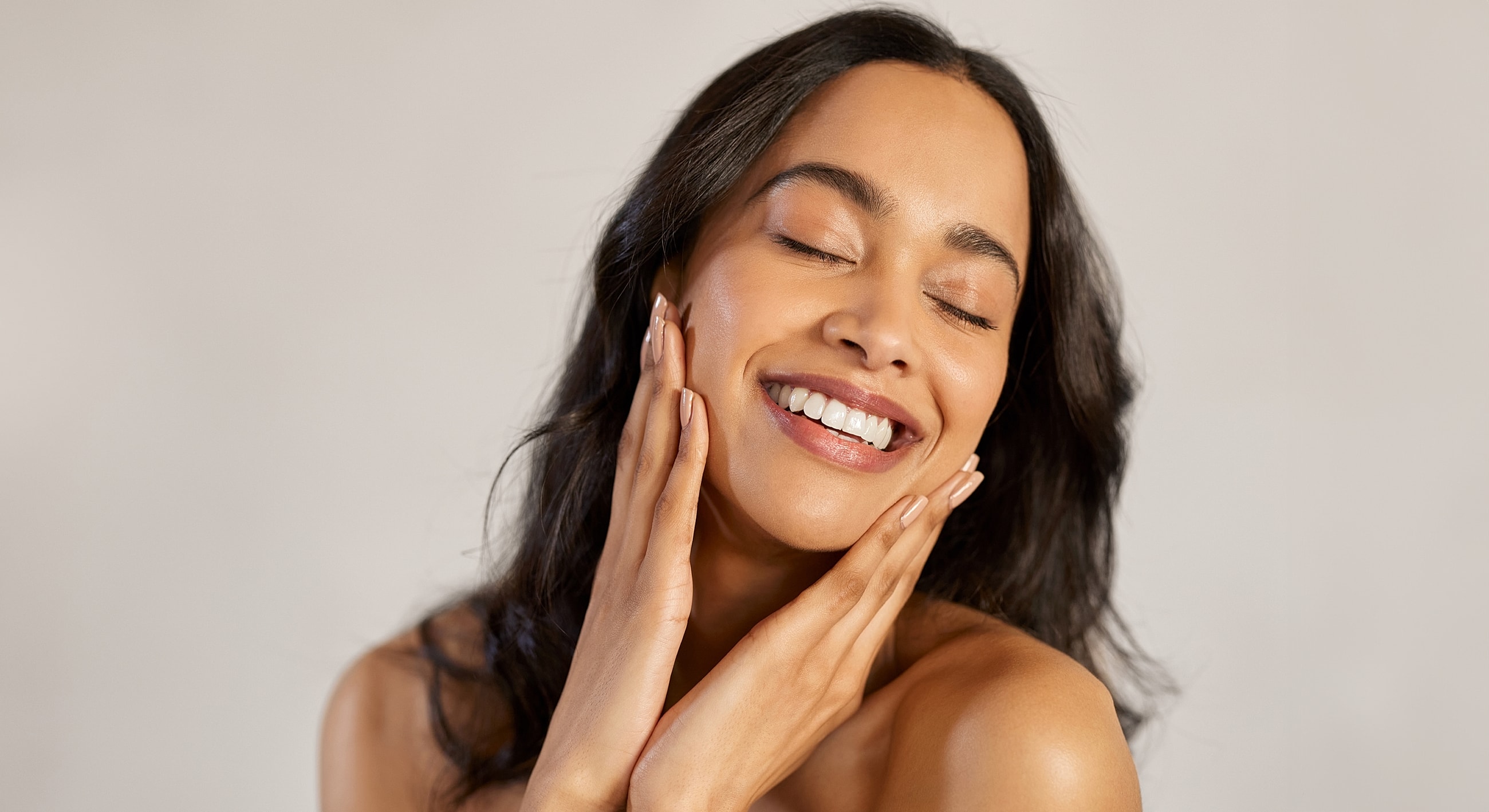 Smiling woman touching her face warmly