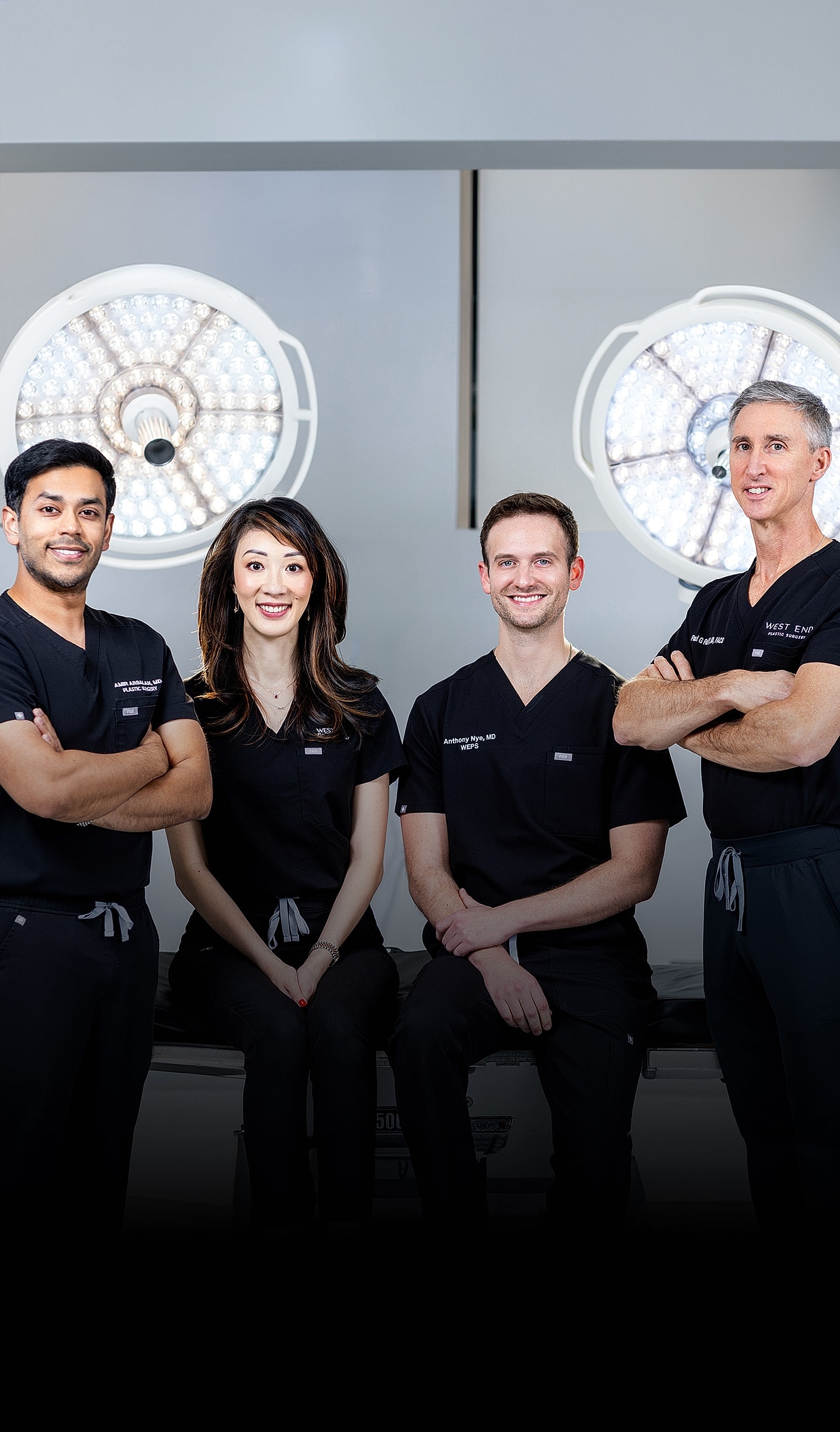 Medical team in surgical attire, smiling together.
